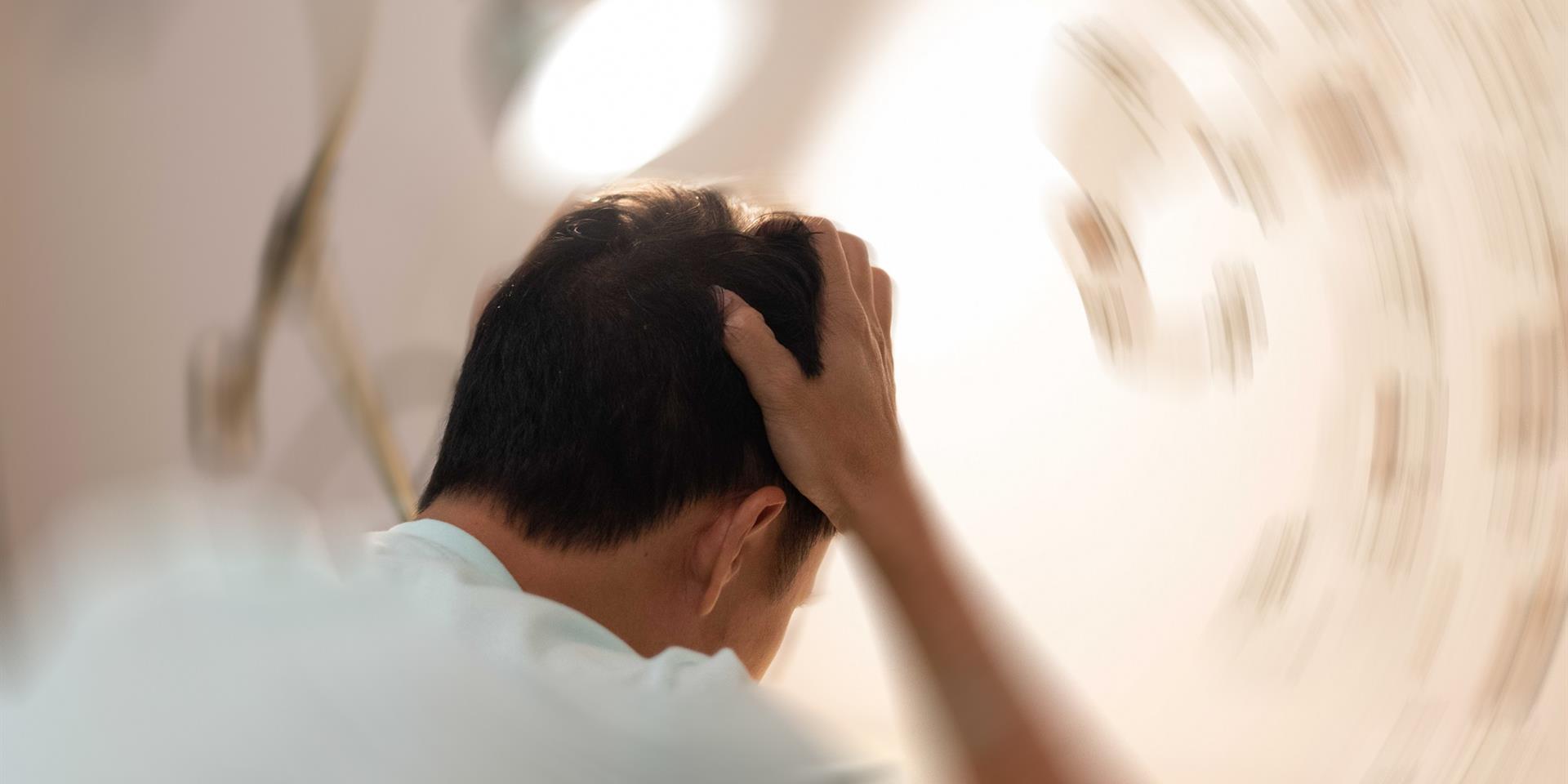 בחור שסובל מסחרחורת (ורטיגו) מחזיק את הראש