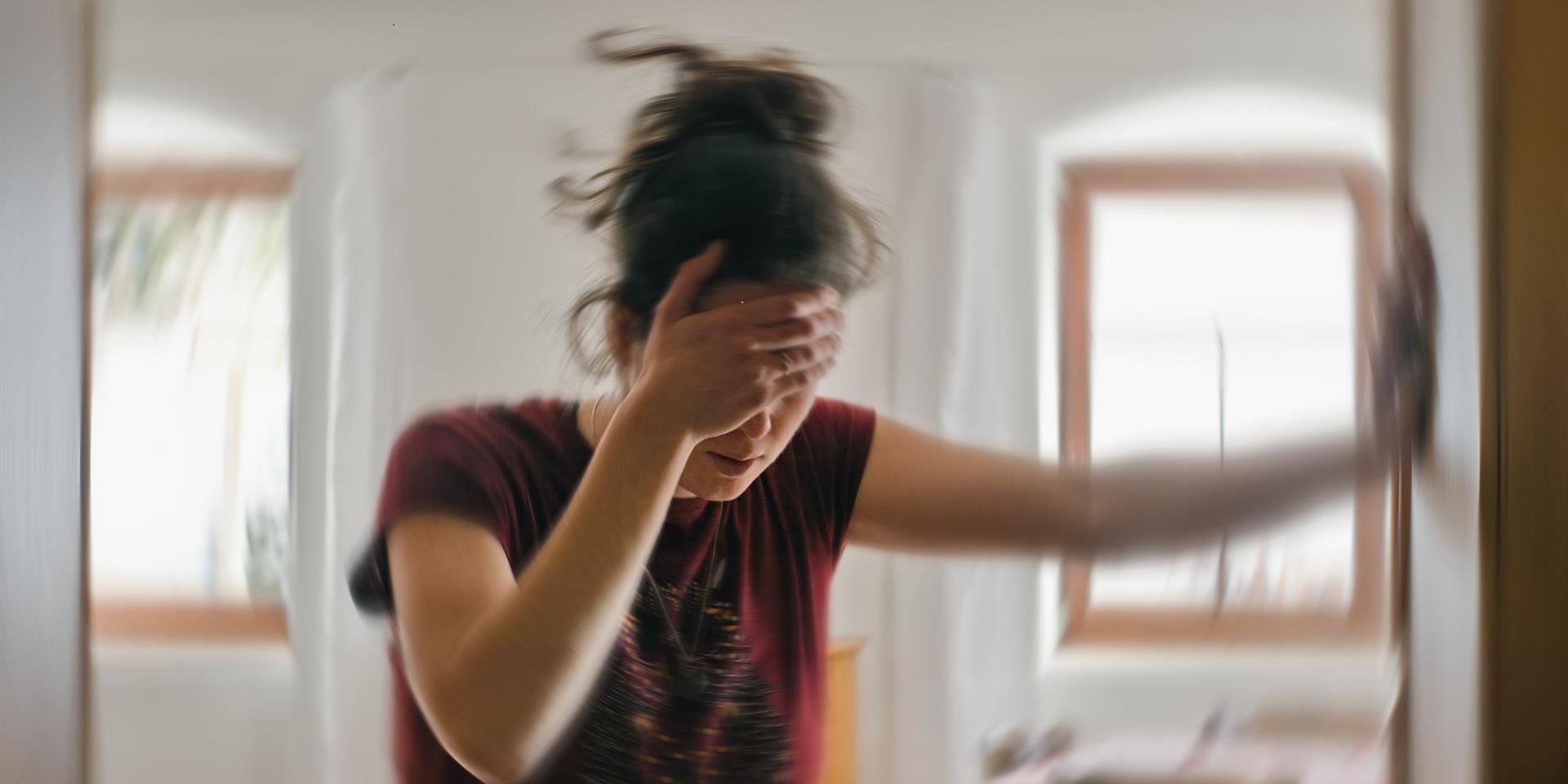 בחורה עומדת ומחזיקה את הראש כשידה נשענת על הקיר
