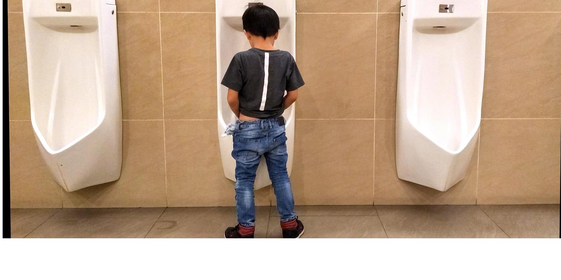 ילד משתין בשירותים ציבוריים
